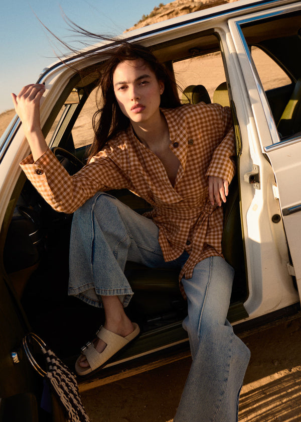 Model standing outside in sweatshirt, jeans and matching denim jacket.