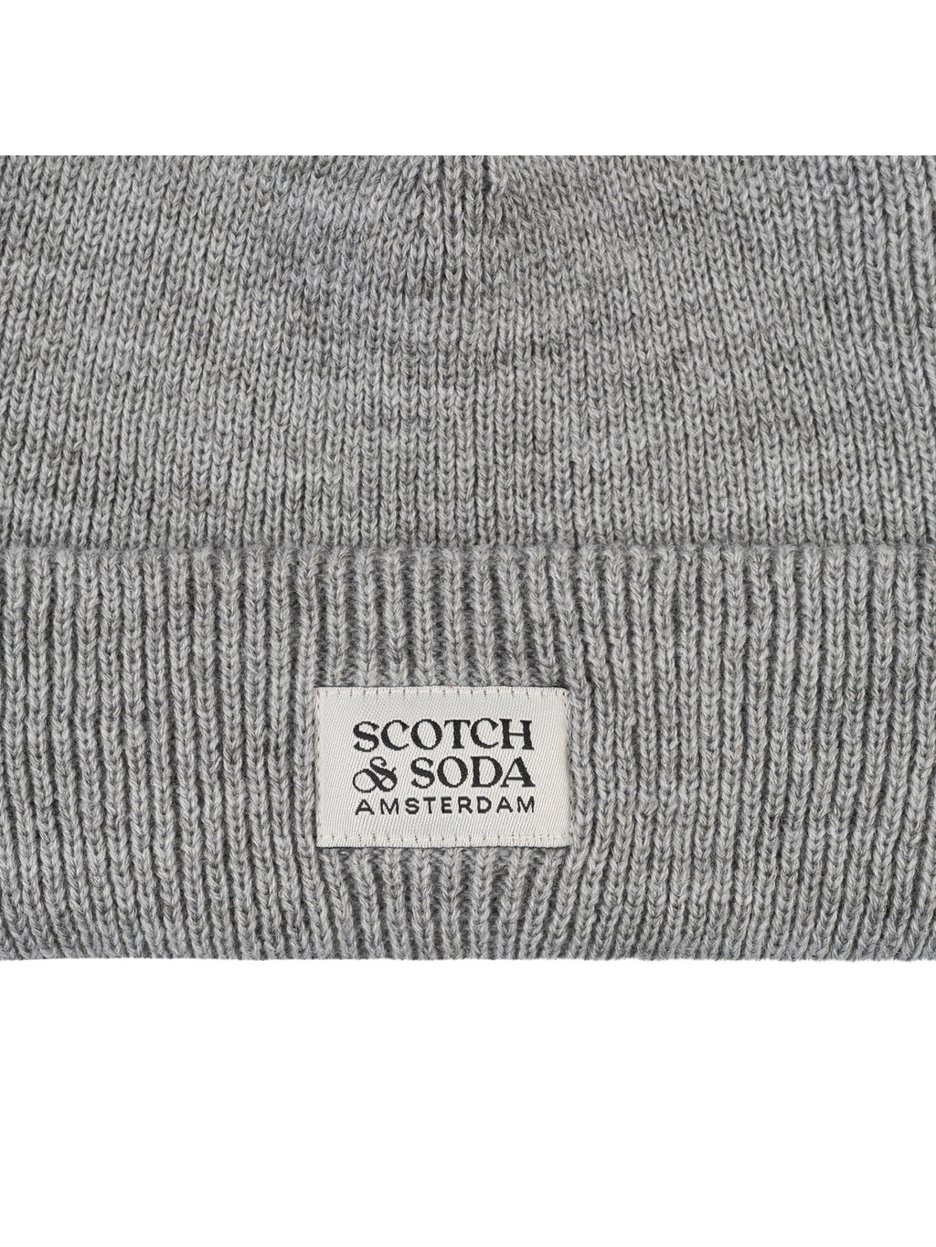 Close-up of a gray ribbed knit beanie with a white rectangular label reading SCOTCH & SODA AMSTERDAM.