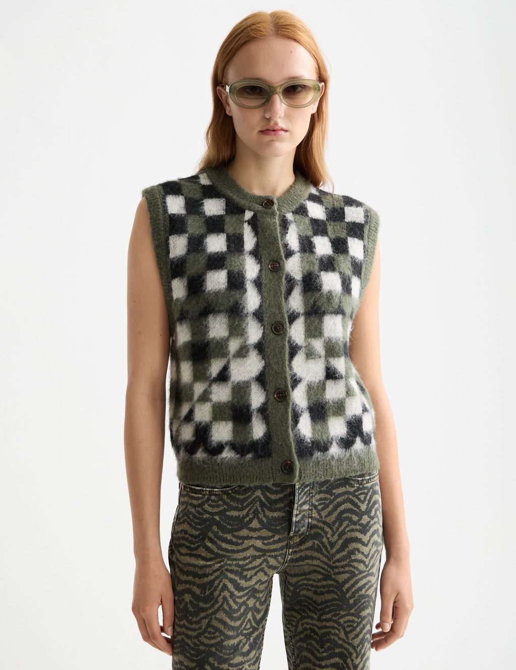 Person wearing a checkered vest and patterned pants on a white background