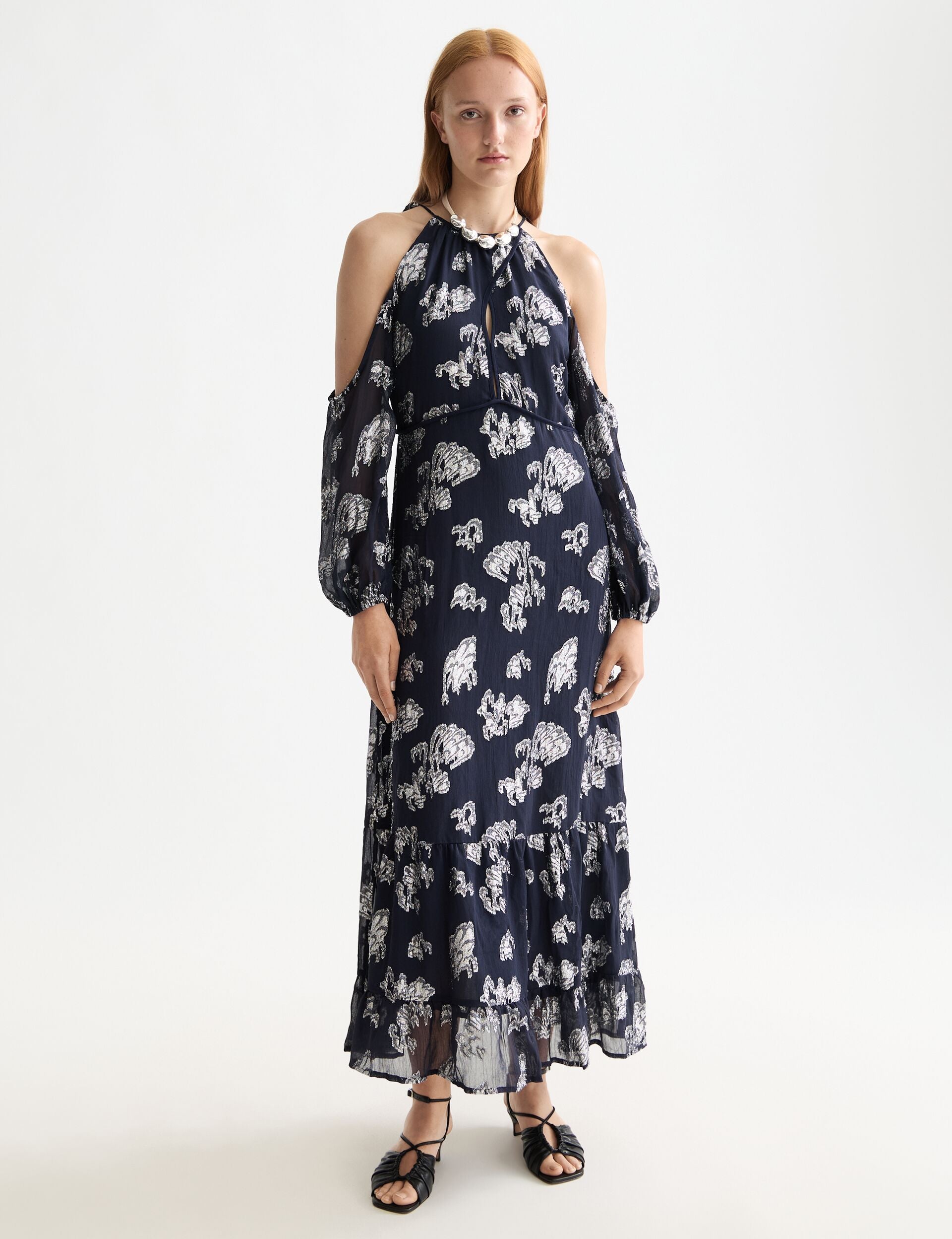 Woman wearing a navy floral dress on a white background